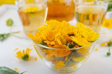 Tıbbi taze çiçekler ve calendula çaydanlık ve bardak bitkisel çay