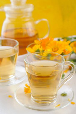 Tıbbi taze çiçekler ve calendula çaydanlık ve bardak bitkisel çay