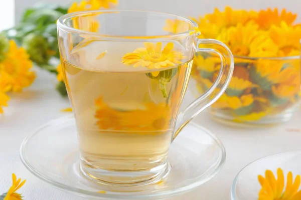 Medicinal fresh flowers and herbal tea of calendula in teapot and cups — Stock Photo, Image