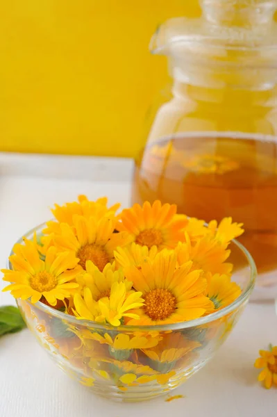 Лекарственные свежие цветы и травяной чай из календулы в чайнике и чашки — стоковое фото
