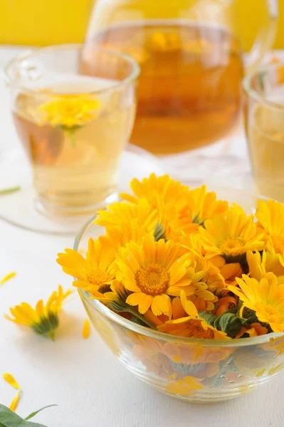 Fleurs fraîches médicinales et tisane de calendula dans la théière et les tasses — Photo