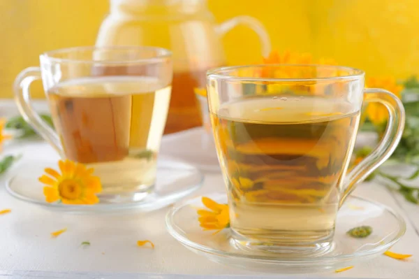 Medicinal fresh flowers and herbal tea of calendula in teapot and cups — Stock Photo, Image