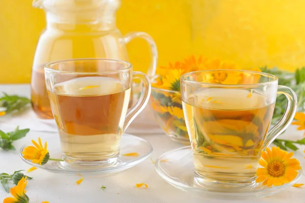 Medizinische frische Blumen und Kräutertee aus Ringelblumen in Teekannen und Tassen — Stockfoto