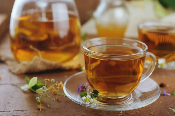 Чашки травяного чая с травяными цветами и клубникой — стоковое фото
