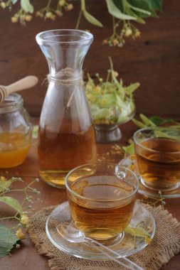 Bal ve ıhlamur çiçek ahşap arka plan üzerinde bir kase ile ıhlamur çayı 