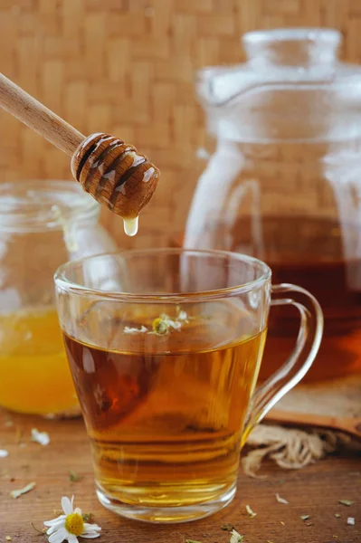 Bylinné Heřmánkový čaj, med a čerstvé květiny na rustikální dřevěný stůl — Stock fotografie