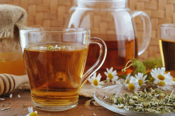 Kräuter-Kamillentee, Honig und frische Blumen auf rustikalem Holztisch — Stockfoto