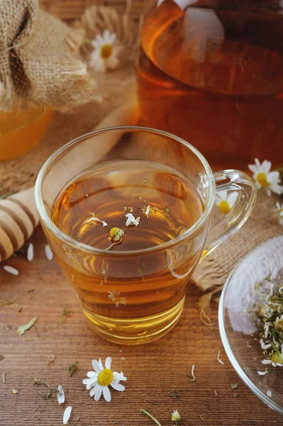 Växtbaserade kamomillte, honung och färska blommor på rustika träbord — Stockfoto