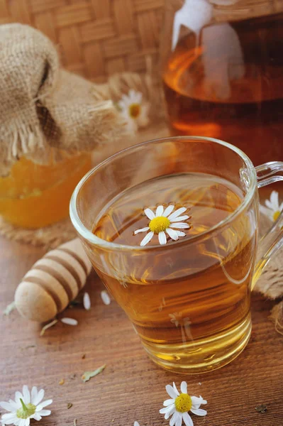 Växtbaserade kamomillte, honung och färska blommor på rustika träbord — Stockfoto
