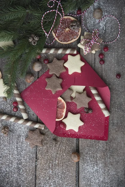 Envelope, cookies and christmas decor on a wooden background — Stock Photo, Image