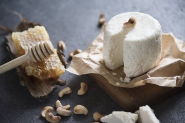 yumuşak peynir, bal ve fındık karanlık bir arka plan üzerinde