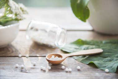 Doğal arka planda muz, otlar, homeopatik granüller ve kapsüller. Alternatif tıp homeopati ve naturopati.