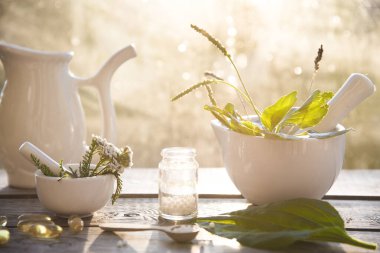 Doğal arka planda muz, otlar, homeopatik granüller ve kapsüller. Alternatif tıp homeopati ve naturopati.