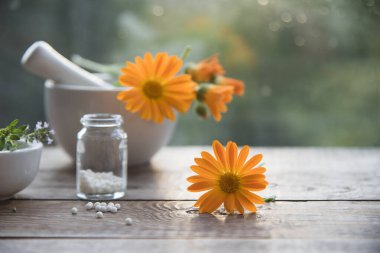 Takvim çiçekleri ve doğal arka planda homeopatik granüller. homeopati ve naturopati.