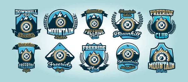 Conjunto colorido de logotipos, emblemas, montañas de piñón de bicicleta en el fondo, ilustración vectorial aislada. Club cuesta abajo, freeride . — Vector de stock