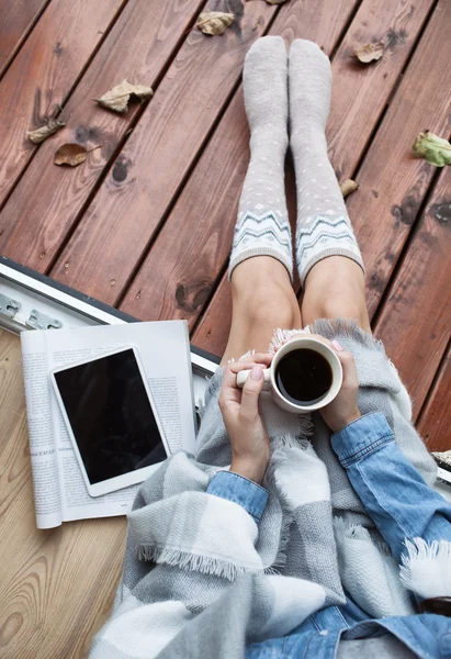 Жінка з чашкою кави, планшетним комп'ютером і паперовим журналом — стокове фото