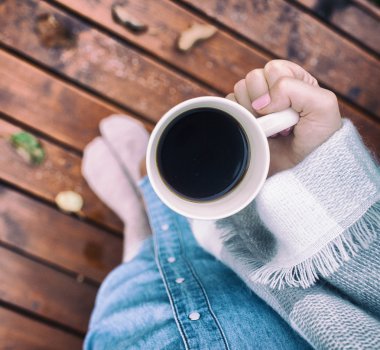 Bir fincan kahve tutan kadın..