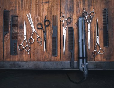 Stylish professional barber scissors on vintage wooden table, hairdresser salon concept, hairdressing tool set. Haircut accessories