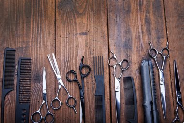Stylish professional barber scissors on vintage wooden table, hairdresser salon concept, hairdressing tool set. Haircut accessories