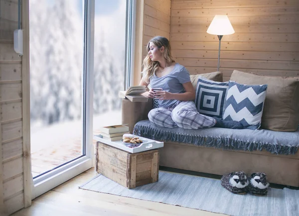 Jonge Mooie Blonde Vrouw Met Boek Zit Thuis Woonkamer Bij — Stockfoto