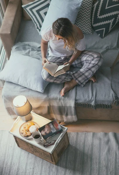 Young Blonde Woman Reading Paper Book Story Home Living Room Stockbild