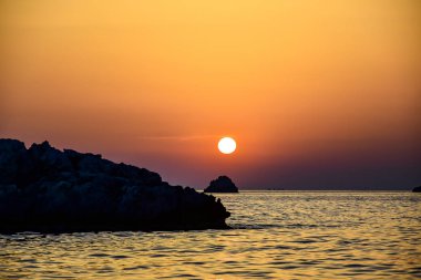 Günbatımı, sarı-turuncu gökyüzü.