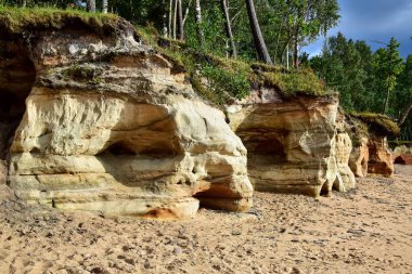 Kumsalda sarı-bej kayalar.