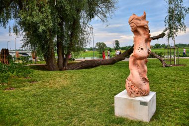 Jelgava, Letonya - 06.08.2019: Kumlu figürler festivali günlerinde büyük boy seramik heykel, parkın arka planında insan yüzü olan kırmızı renkli bir heykel.