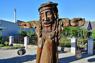 Trakenai, Litvanya - 06.21.2014: Traken yakınlarındaki bir yol kenarındaki kafede, gündüz vakti mavi gökyüzü bulunan, tahtadan yapılmış yaşlı bir adamın muhteşem kahverengi figürü.