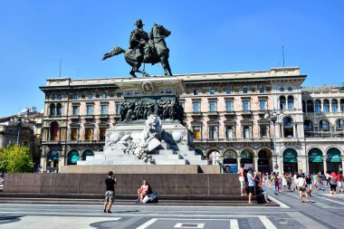 Milan, İtalya - 08.08.2016: Victor Emmanuel Anıtı (Vittorio Emanuele II), şehrin ana meydanında - Piazza del Duomo, aşağıda beyaz bir aslan, turistler anıtın yanında fotoğraflandı.