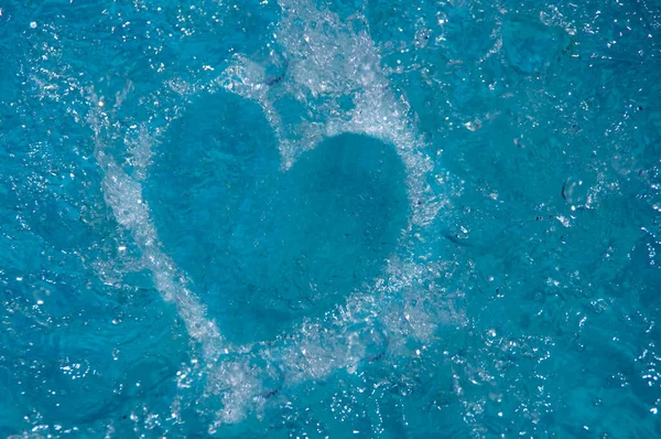 Heart on blue water surface