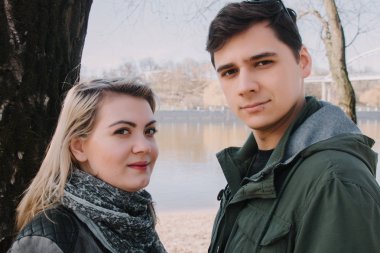 Neşeli çift öpücük birbirlerine sevgi dolu. Nehir banka ve kucaklama