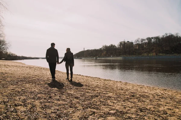 Cheerful loving each other couple kisses. Walk on the river bank and embrace — Stock Photo, Image