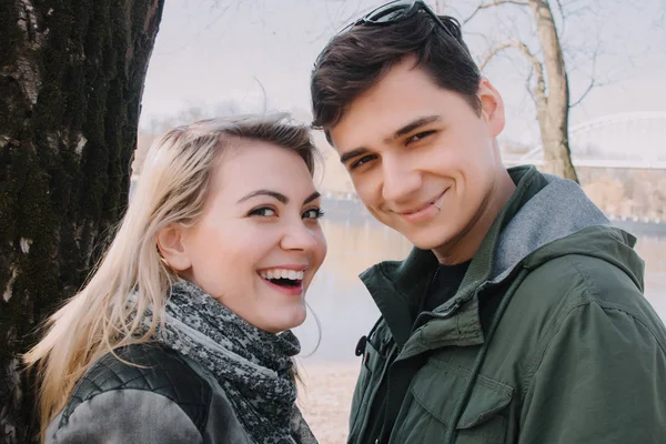 Alegre amándose pareja besos. Caminar por la orilla del río y abrazar —  Fotos de Stock