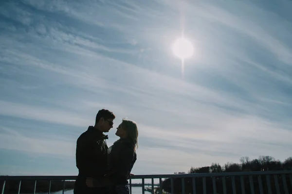 Linda amar uns aos outros casal está de pé na ponte sorrindo e beijando . — Fotografia de Stock