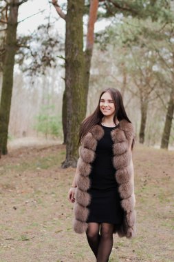 Kürk giymiş bir ormanda çok güzel bir kız portresi