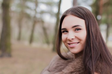 Kürk giymiş bir ormanda çok güzel bir kız portresi