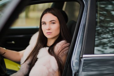 Çok güzel bir kız bir arabada Kürk giymiş bir ormandaki portresi