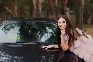 Çok güzel bir kız bir arabada Kürk giymiş bir ormandaki portresi