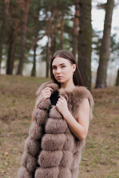 Retrato de una chica muy hermosa en un bosque vestida de piel — Foto de Stock