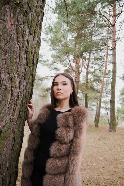 Retrato de uma menina muito bonita em uma floresta vestida de pele — Fotografia de Stock