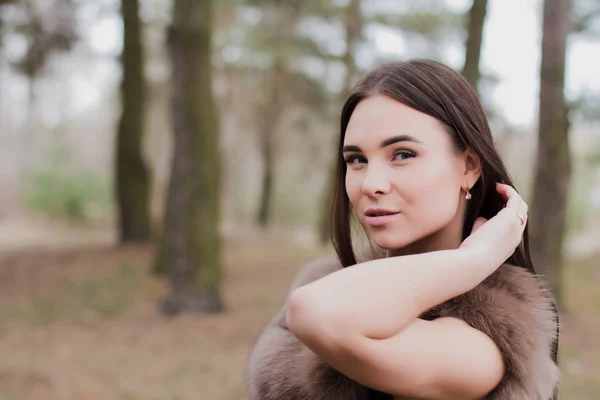 Portrait of a very beautiful girl in a forest dressed in fur — Stock Photo, Image