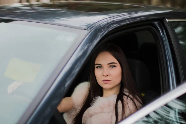 Ritratto di una bellissima ragazza in un bosco vestita di pelliccia in macchina — Foto Stock