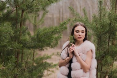 Kürk giymiş bir ormanda çok güzel bir kız portresi