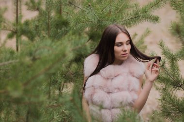 Kürk giymiş bir ormanda çok güzel bir kız portresi