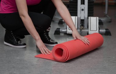 Güzel kız halının üstünde bir fitness kulübünde egzersiz