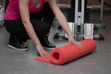 Güzel kız halının üstünde bir fitness kulübünde egzersiz
