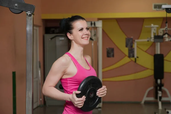 Menina bonita está de pé com um equipamento desportivo no clube de fitness . — Fotografia de Stock