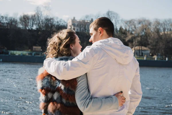 Couple heureux amoureux embrasser et partager des émotions, se tenant la main sur la rive de la rivière — Photo