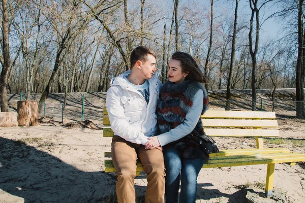 Pasangan bahagia saling memeluk dan berbagi emosi, berpegangan tangan di bangku dekat sungai — Stok Foto